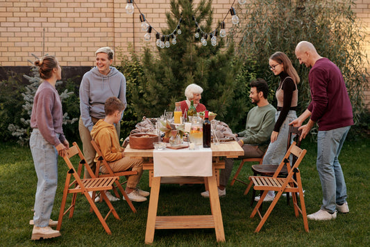 Family with different food needs sitting at a table outside for dinner