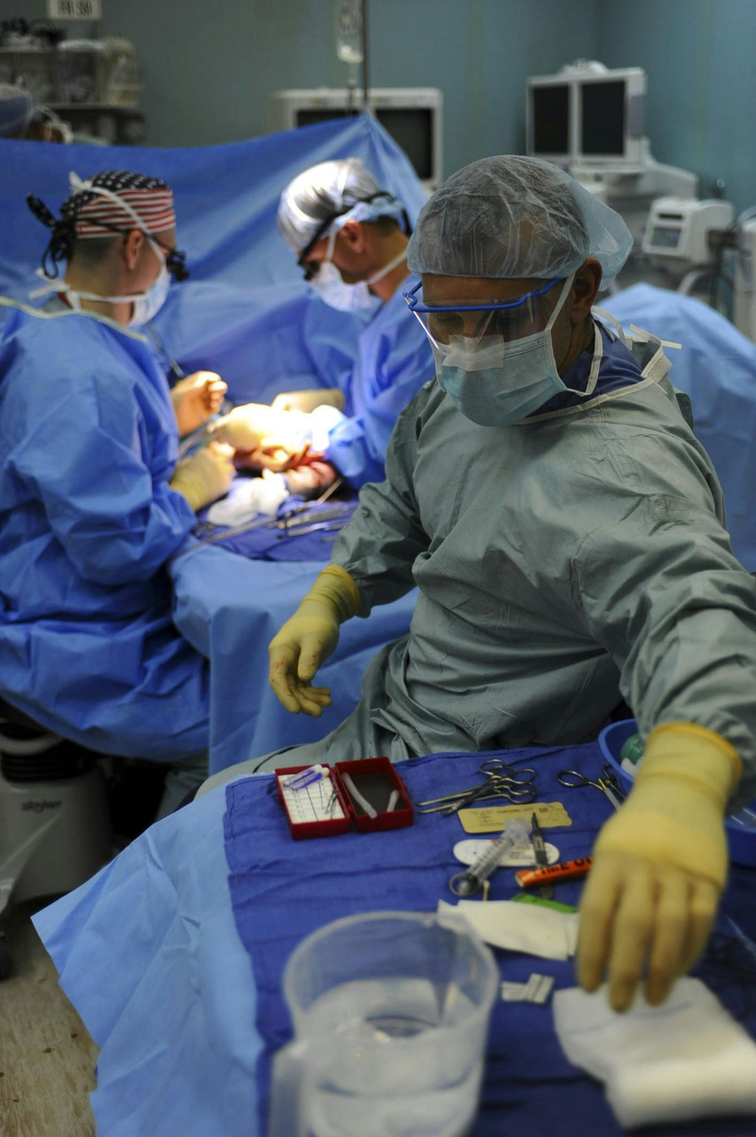 Three doctors in the OR preforming a laryngectomy