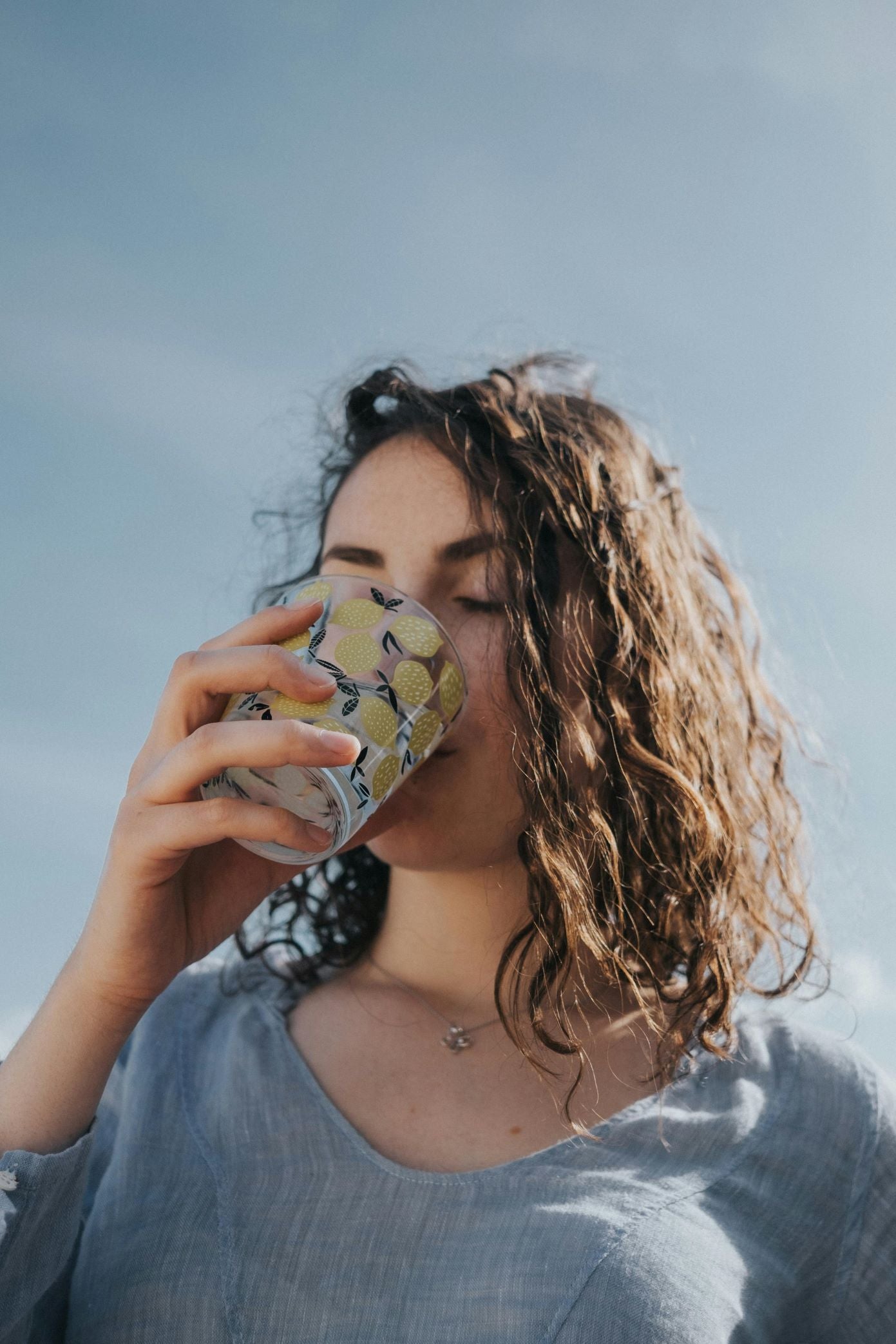 woman drinking from a lemon cup