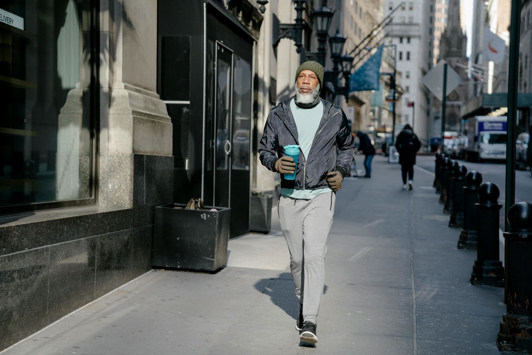 man walking on the street with water bottle filled with thickened water